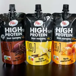 Trzy opakowania napoju proteinowego Pilos z Lidla: czekoladowy, waniliowy i solony karmel.