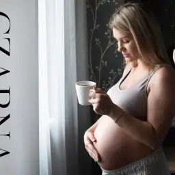 Ciężarna kobieta pije czarną herbatę, zastanawiając się, jaka herbata w ciąży jest bezpieczna.