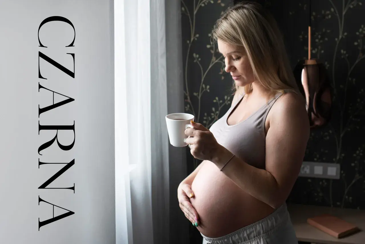 Ciężarna kobieta pije czarną herbatę, zastanawiając się, jaka herbata w ciąży jest bezpieczna.